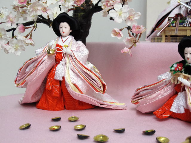 淡い淡いピンクのお雛様を毛氈を敷いた二段飾りにしました。桐箱に収納します。桜の木が美しい創作雛人形です。