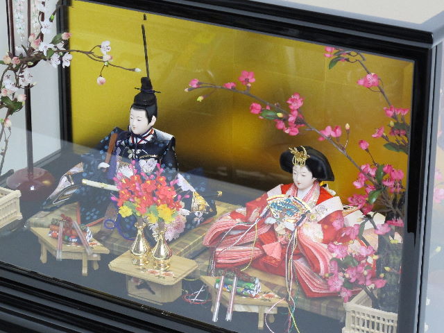 流水模様の赤生地に華やかな桜刺繍のお雛さまをガラスケースに入れました。固定式でないため飾る楽しみが味わえる雛人形です。