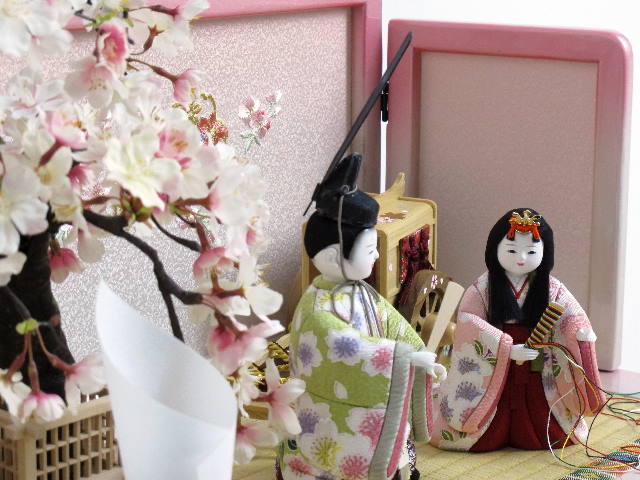 華やかな衣装の木目込み人形です。ほんわかかわいいピンクの収納箱に飾ります。
