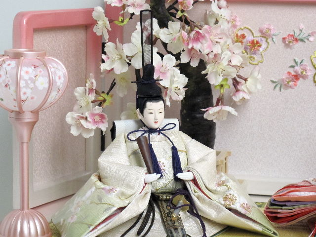 桜の刺繍が特徴の姫はピンク、殿はグリーンのグラデーションが綺麗なお雛さまをかわいいホワイトピンク収納台に桜で飾りました。