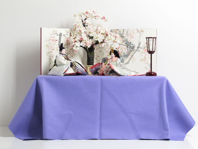 春らしいうぐいす色の雛人形を手描き桜屏風と桜で彩る桐収納飾り