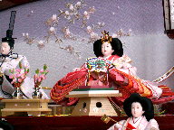 桜色の衣装に桜柄を織り込んだ淡いピンクの雛人形三段飾り