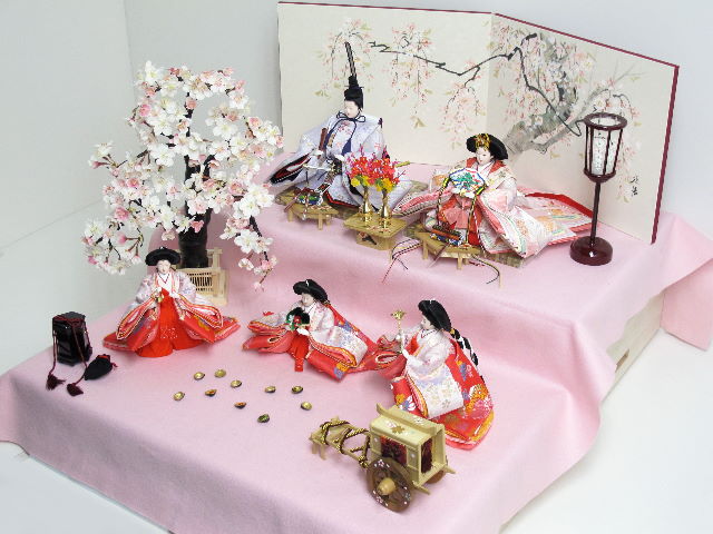 桜の木の元で、貝合わせを楽しむ官女たち。それを眺める仲良く寄り添う女雛・男雛をイメージした雛人形です。