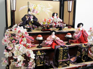 ピンクの大きめお雛様を茶塗りぼかしの屏風と90cm間口の台に飾ったボリュームのある三段飾りです。