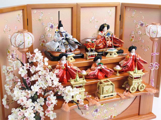 オレンジ女雛とグレー男雛の五人揃いを三段に飾り、大桜を脇に置いた豪華な飾りです。桜のある御殿で宴をしているような素敵な雰囲気になりました。