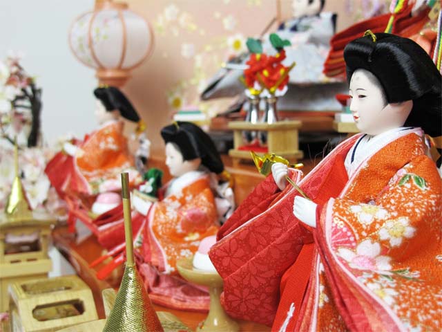 オレンジ女雛とグレー男雛の五人揃いを三段に飾り、大桜を脇に置いた豪華な飾りです。桜のある御殿で宴をしているような素敵な雰囲気になりました。