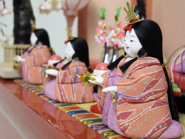 落ち着いた衣装の木目込み人形の五人揃いです。桜の刺繍がポイントのパールローズピンクの収納台に飾りました。