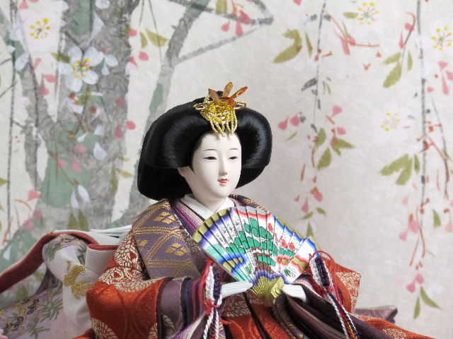 平安貴族の愛用した有職文様、鶴の丸を正絹衣装に織り込み着せ付けた落ち着いたお雛さまと嫁入り道具一式を毛氈三段の上に並べます。オプションで毛氈・屏風がアレンジできます。