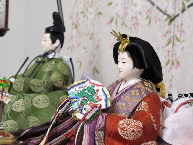 平安貴族の愛用した有職文様、鶴の丸を正絹衣装に織り込み着せ付けた落ち着いたお雛さまと嫁入り道具一式を毛氈三段の上に並べます。オプションで毛氈・屏風がアレンジできます。