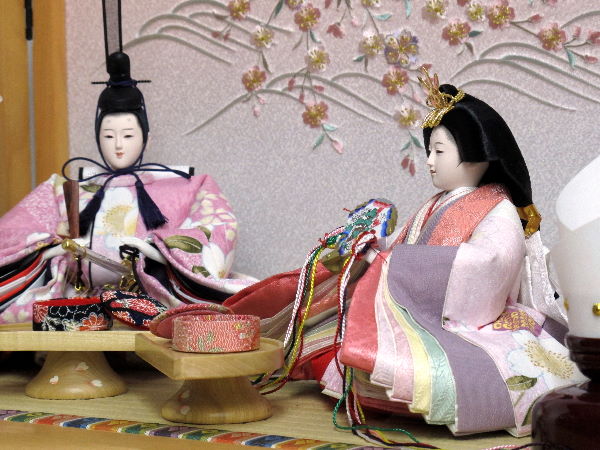 桃色のかわいいおひなさまをコンパクトな収納箱と組み合わせて収納上手な雛人形にしました。桜の下のひと時です。