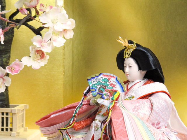 淡い桜色の女雛と藤色の男雛をピンクの毛氈で桐箱の上に金屏風で飾りました。