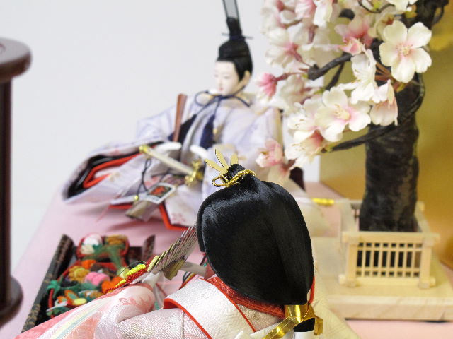 淡い桜色の女雛と藤色の男雛をピンクの毛氈で桐箱の上に金屏風で飾りました。
