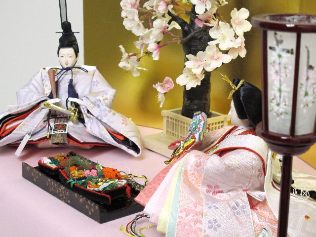 淡い桜色の女雛と藤色の男雛をピンクの毛氈で桐箱の上に金屏風で飾りました。