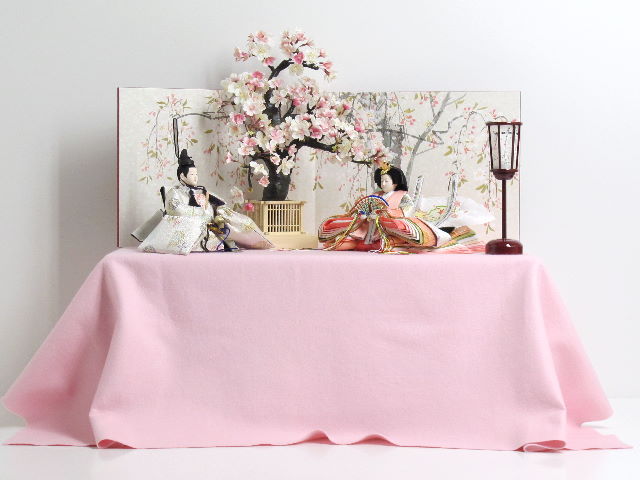 白とピンクを重ねた華やかなお雛様を手描き桜屏風で彩る桐収納式雛人形