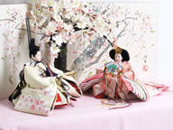 桜色のおひなさまをを桜屏風の前に大きな桜の木と共に優雅に飾りました。桐箱に収める便利な収納タイプです。