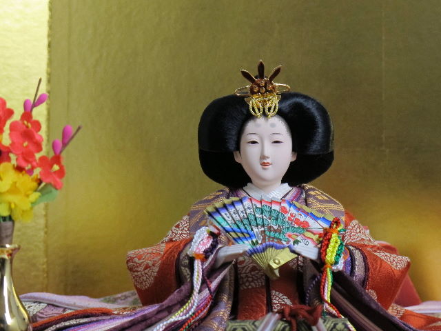 平安貴族の愛用した有職文様、鶴の丸を正絹衣装に織り込み着せ付けた落ち着いたお雛さまを桐箱を台として金屏風で飾りました。便利な収納タイプです。