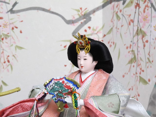 薄緑と紫の落ち着いた正絹衣装の雛人形を品良く手描き桜屏風の前に雪洞と三宝を添えて並べました。