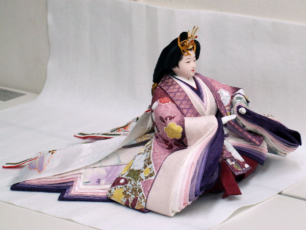 近代的な紫の色合いの衣装の雛人形を金屏風とお花で飾った創作親王飾り