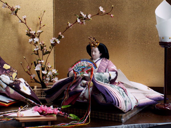 近代的な紫の色合いの衣装の雛人形を金屏風とお花で飾った創作親王飾り