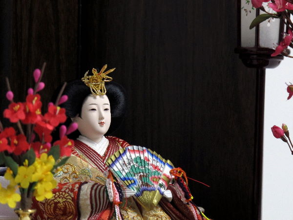 鳳凰が金で織り込まれた豪華な衣装の雛人形を人気の梅飾りにしました。