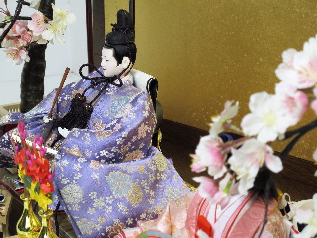 桜模様の明るく清々しい衣装を着せ付けたの仕立て自慢のおひなさまを創作金屏風と巻物前飾り、左右の桜で重厚に飾った雛人形です。