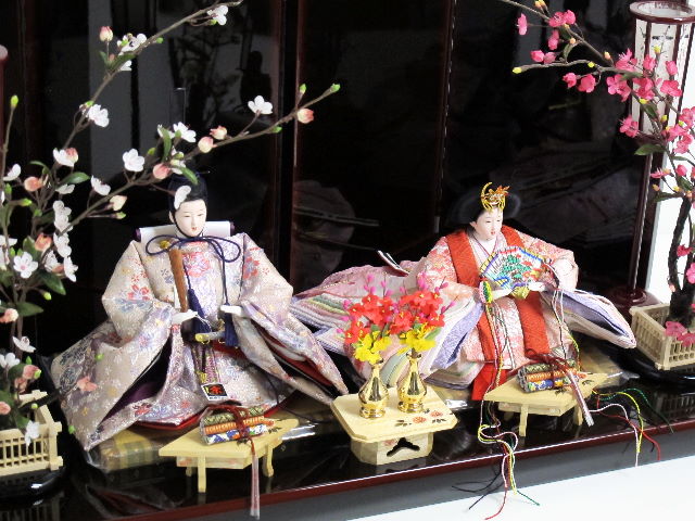 縦糸と横糸で奏でる優雅な光沢。美しい赤い女雛と紫の男雛を両脇から梅で飾る人気のコーディネートです。
