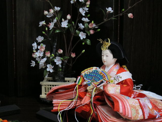 流水模様の赤生地に華やかな桜刺繍のお雛様をゆったりと斜めに飾りました。白梅で彩る創作平飾りです。