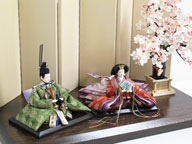 平安貴族の愛用した有職文様、鶴の丸を正絹衣装に織り込み着せ付けた落ち着いたお雛さまです。大きな桜の下に飾ります。