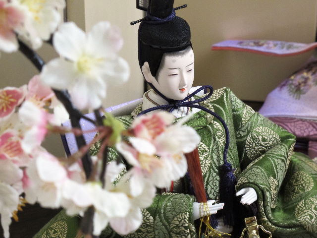 平安貴族の愛用した有職文様、鶴の丸を正絹衣装に織り込み着せ付けた落ち着いたお雛さまです。両脇に桜を飾りました。