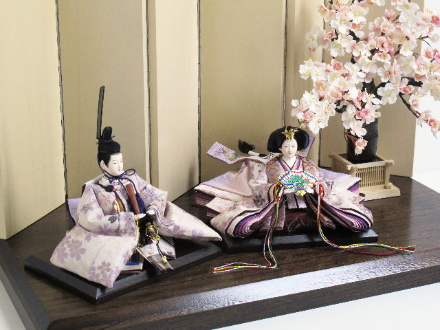 淡い紫地に紫の桜を正絹衣装に織り込んだ優雅で高貴なお雛さまです。大きな桜の下に飾ります。