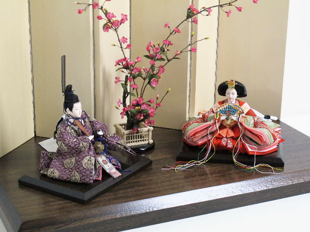 和を感じるおとなしい色合いのお雛様です。女雛と男雛の間に紅梅の木を置くシンプルな飾りです。